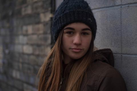 Young person looking at the camera in a beanie hat