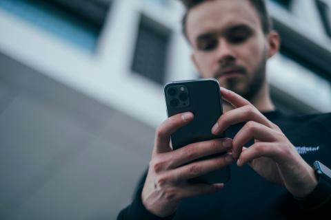 A man looks down at a mobile phone