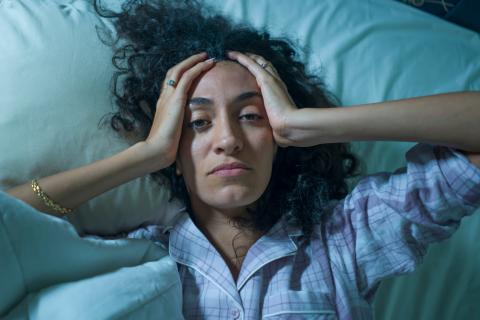 woman in bed feeling anxious