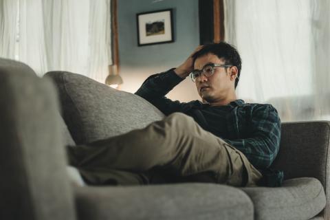 man on sofa feeling anxious