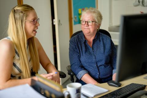 Two women talking in office at work